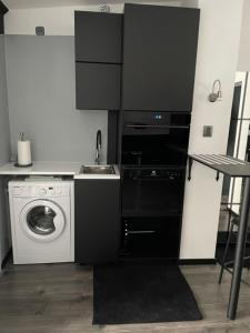 a kitchen with a washing machine and a sink at Ingress in Bytom