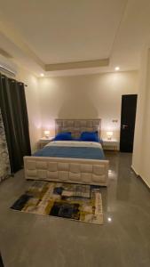 1 dormitorio con 1 cama grande y 1 alfombra en The One en Yaundé