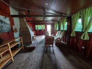 sala de estar con suelo de madera y chimenea de ladrillo en Alla Arriba en Las Cruces