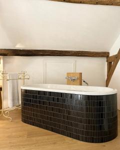 ein Bad mit einer Badewanne in einem Zimmer in der Unterkunft Hoeve Berghof in Heerlen