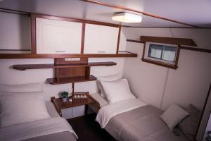 阿姆斯特丹Unique Hotelboat botel Lena Maria的有两张床和一扇窗户的小房间