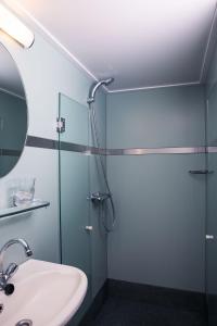 a bathroom with a glass shower and a sink at Botel Lena Maria in Amsterdam