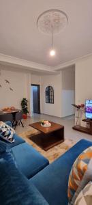 een woonkamer met een blauwe bank en een salontafel bij EXCELLENT rapport Qualité Prix pour cet Appartement 3 étoiles Neuf 2P Tout Confort Résidence Golf Mesnana Tanger in Tanger