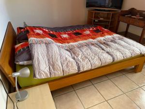a bed with a quilt on it in a room at Chambres d'hôtes in Les Genevez