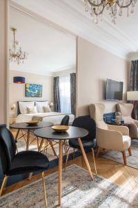 a living room with a couch and a table and chairs at LE BEAU MARAIS - Luxury Apartments, AIR COND, LIFT in Paris