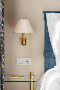 a lamp on a side table next to a bed at LE BEAU MARAIS - Luxury Apartments, AIR COND, LIFT in Paris