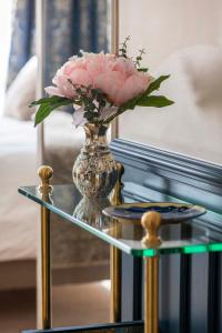 a vase with pink flowers on a glass table at LE BEAU MARAIS - Luxury Apartments, AIR COND, LIFT in Paris +151 photos