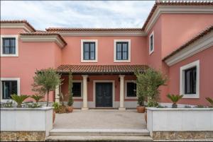 una casa rosa con cortile di Colorful Villa with pool by OTYNA AM a Estoril