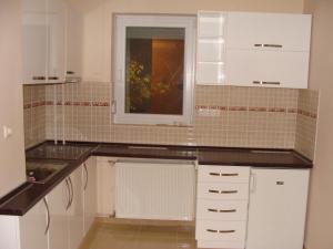 a kitchen with white cabinets and a window in it at Centrum Business Apartman Szekszárd in Szekszárd