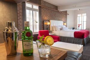 een fles wijn en een glas op een tafel in een hotelkamer bij Hôtel des Coutellier in Québec