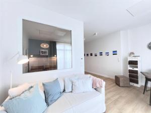 - un salon blanc avec un canapé blanc et une table dans l'établissement Haus Alexandra - Ferienwohnung Dat Büdche, à Wangerooge