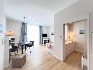 a living room with a desk and a dining room at Haus Alexandra - Ferienwohnung Dat Büdche in Wangerooge