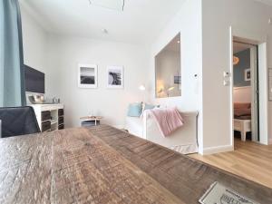 a white living room with a couch and a table at Haus Alexandra - Ferienwohnung Dat Büdche in Wangerooge