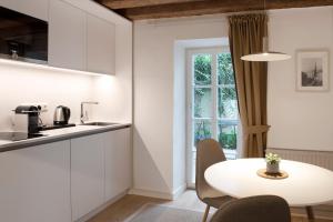 a white kitchen with a white table and chairs at Quartier 99 in Innsbruck