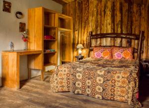 a bedroom with a bed and a wooden wall at Alla Arriba in Las Cruces