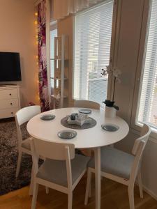 a white table and chairs in a room with windows at River in Rovaniemi