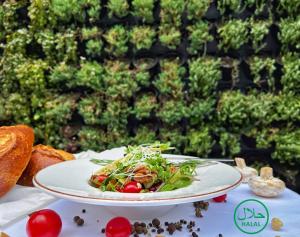 a plate of food on a table with a salad at Marjan Plaza Hotel in Tbilisi City