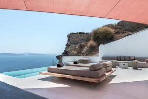 Habitación con cama y piscina en Andronis Luxury Suites, en Oia