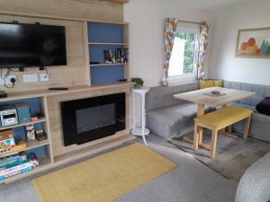 a living room with a television and a couch and a table at Camelot Holiday Park, Longtown, Tranquility 21 Coworth in Carlisle