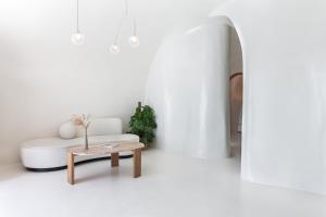 a white living room with a white couch and a table at Andronis Luxury Suites in Oia