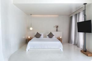 a bedroom with a white bed and white walls at Andronis Luxury Suites in Oia