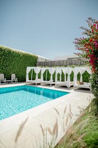 a swimming pool with white umbrellas and chairs around it at Atlántico Boutique Hotel in Punta del Este