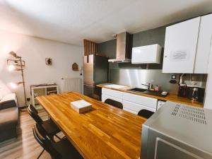 eine Küche mit einem Holztisch im Zimmer in der Unterkunft Appartement meublé 60m2 Le Drômardèchois ARDÈCHE -GESTLOC- in Tournon-sur-Rhône