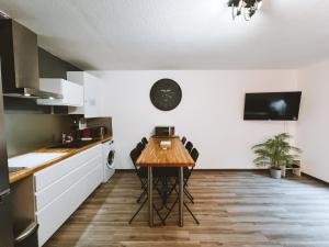 a kitchen with a table and chairs in a room at Le DrômArdèchois - Gîte meublé Ardèche - WIFI Parking - Écolodgîte Drôme ardèche in Tournon-sur-Rhône
