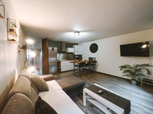 uma sala de estar com um sofá e uma cozinha em Appartement meublé 60m2 Le Drômardèchois ARDÈCHE -GESTLOC- em Tournon-sur-Rhône