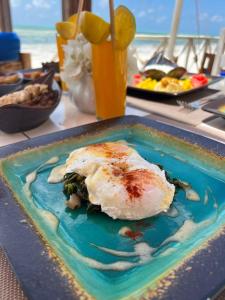 a plate of food with an egg on a table at Equalia Rose hotel in Jambiani