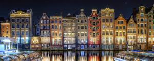 a group of buildings lit up at night at Botel Lena Maria in Amsterdam