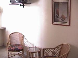 une chambre avec deux chaises et une photo sur le mur dans l'établissement Hotel Don Jorge c.a, à San Antonio del Táchira