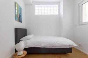 a white bedroom with a bed and a window at Wonderful Two Bedroom Apartment at Limpertsberg with Parking, near Tram in Luxembourg