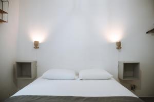 a bedroom with a bed with two lights on the wall at Le DrômArdèchois - Gîte meublé Ardèche - WIFI Parking - Écolodgîte Drôme ardèche in Tournon-sur-Rhône
