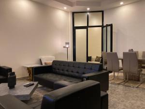 a waiting room with a couch and a table and chairs at The One in Yaoundé