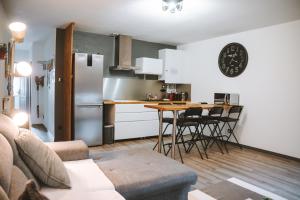 cocina con armarios blancos, mesa y sillas en Appartement meublé 60m2 Le Drômardèchois ARDÈCHE -GESTLOC- en Tournon-sur-Rhône