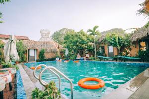 una piscina in un resort con una zattera arancione di Tam Coc Sky Bungalow a Ninh Binh