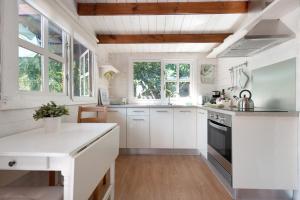 a kitchen with white cabinets and a white counter top at Cottage Hibiscus among Avocados in La Orotava