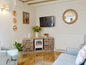 uma sala de estar com lareira e televisão em West Wood Hideaway em Middleton