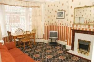 a living room with a couch and a fireplace at Spa Holiday Apartments in Bridlington