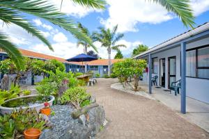 a courtyard of a building with trees and plants at Cortez Motel in Whakatane