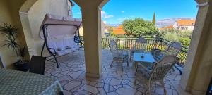 patio con mesa y sillas en el balcón en Apartmani FANI, en Supetar