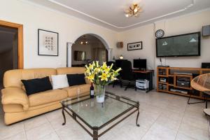Una sala de estar con un sofá y una mesa con flores. en Villa Encantada, en Arona