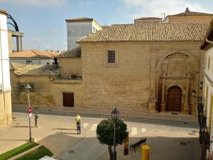 a large brick building with people walking in a courtyard at Balcón del Cardenal in Baeza