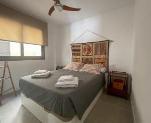 a bedroom with a large bed with two towels on it at Cucurrox in Torrox +13 photos