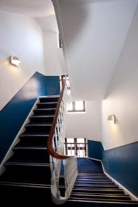 a staircase in a building with blue walls at Go Hotel Saga in Copenhagen