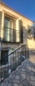un edificio de piedra con balcón y barandilla en Picasso Suites Çeşme, en Cesme