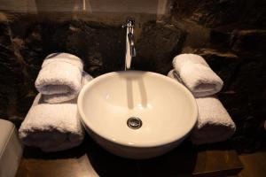 a bathroom with a white sink and towels at Lodge El Portal de Qopuy in Coporaque