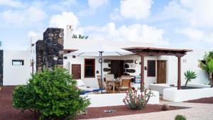 a house with a patio with an umbrella at Casa Margarita 4 in Mala