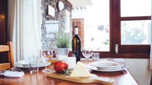 una mesa de madera con una botella de vino y copas en Casa Margarita 3, en Mala